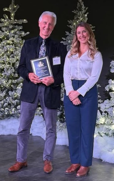 Gerald Duffy accepting the 2025 Community Impact Award from Emmy Ham